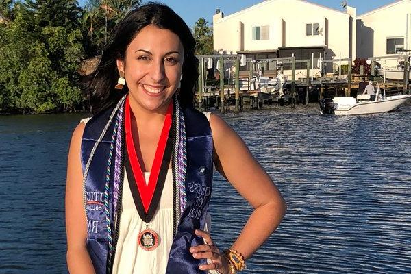 Kim Slezak '21 stands by the water following graduation from UC's ABSN program in Florida.